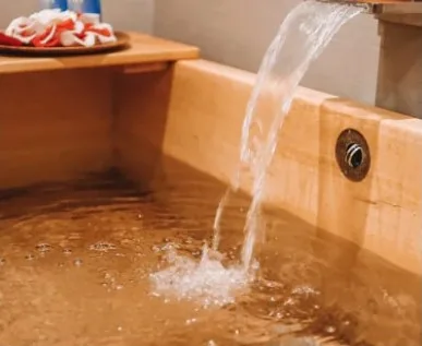 Water pouring into a hinoki wood bath