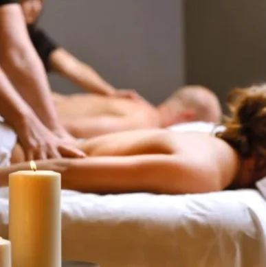Two guests receiving massage by candlelight